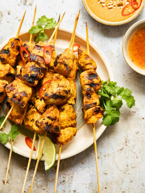 top down view of chicken satay with peanut sauce and red chilli sauce