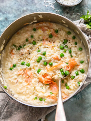 top down view of salmon and pea risotto in a pan