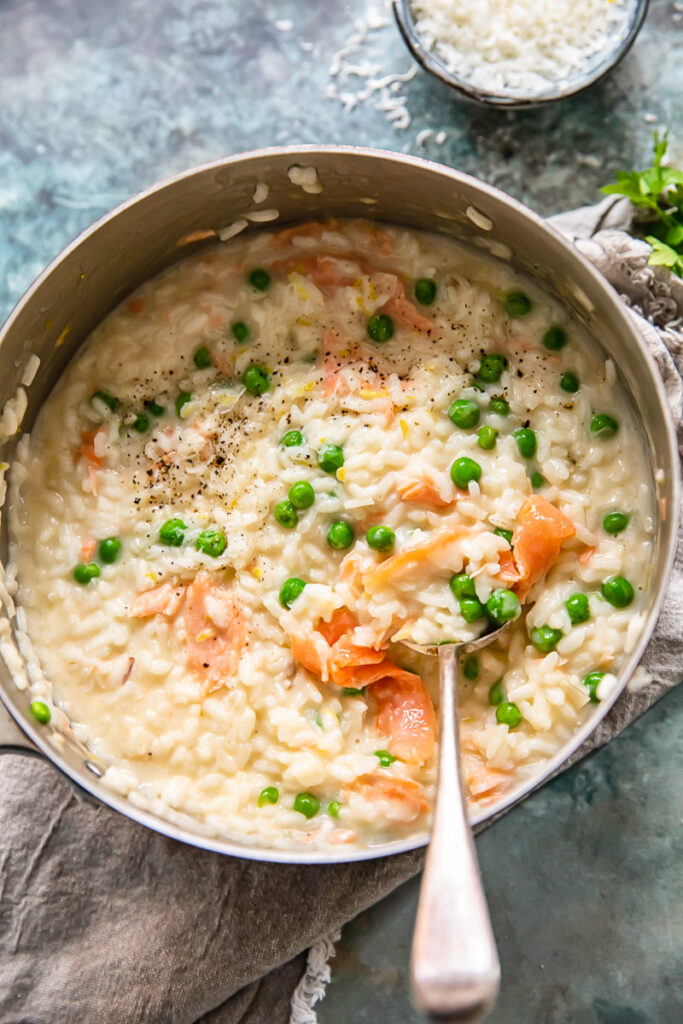 top down view of salmon and pea risotto in a pan