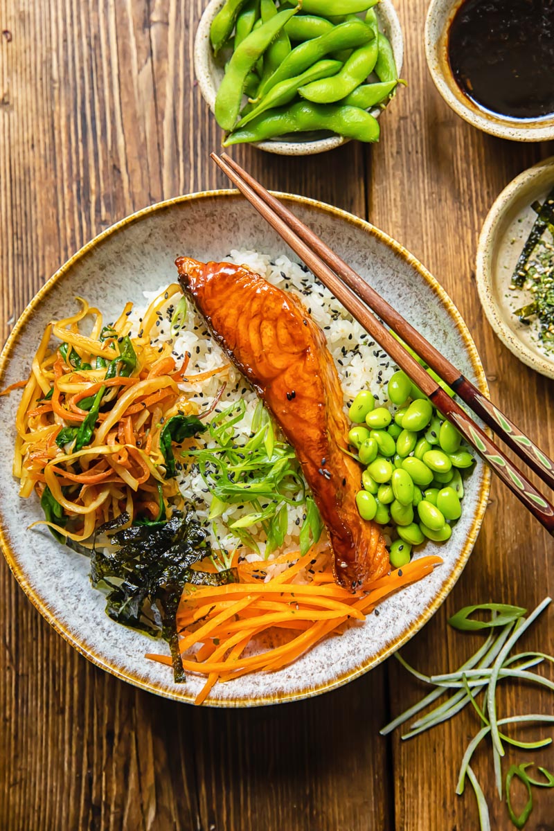 top down view of donburi, bowls filled with edamame beans, teriyaki sauce and furikake