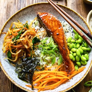 salmon, vegetables and edamame beans on top of rice