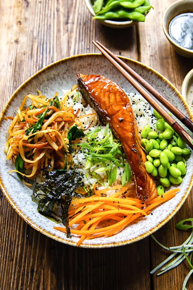 salmon, vegetables and edamame beans on top of rice