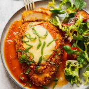 chicken parmesan on a plate with salad