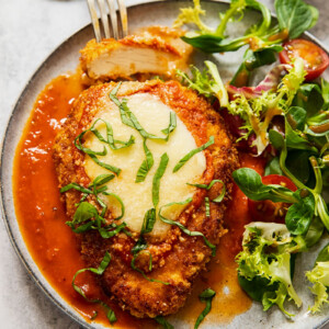 chicken parmesan on a plate with salad
