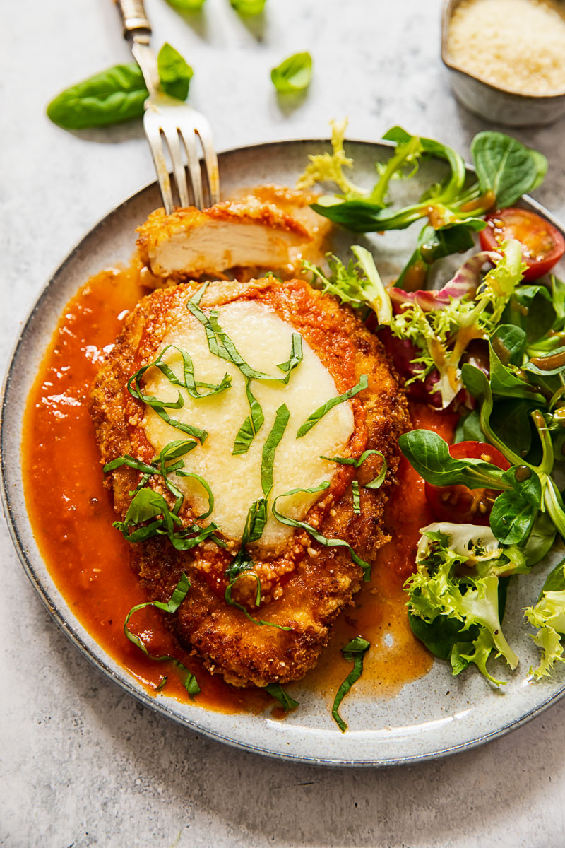chicken parmesan on a plate with salad
