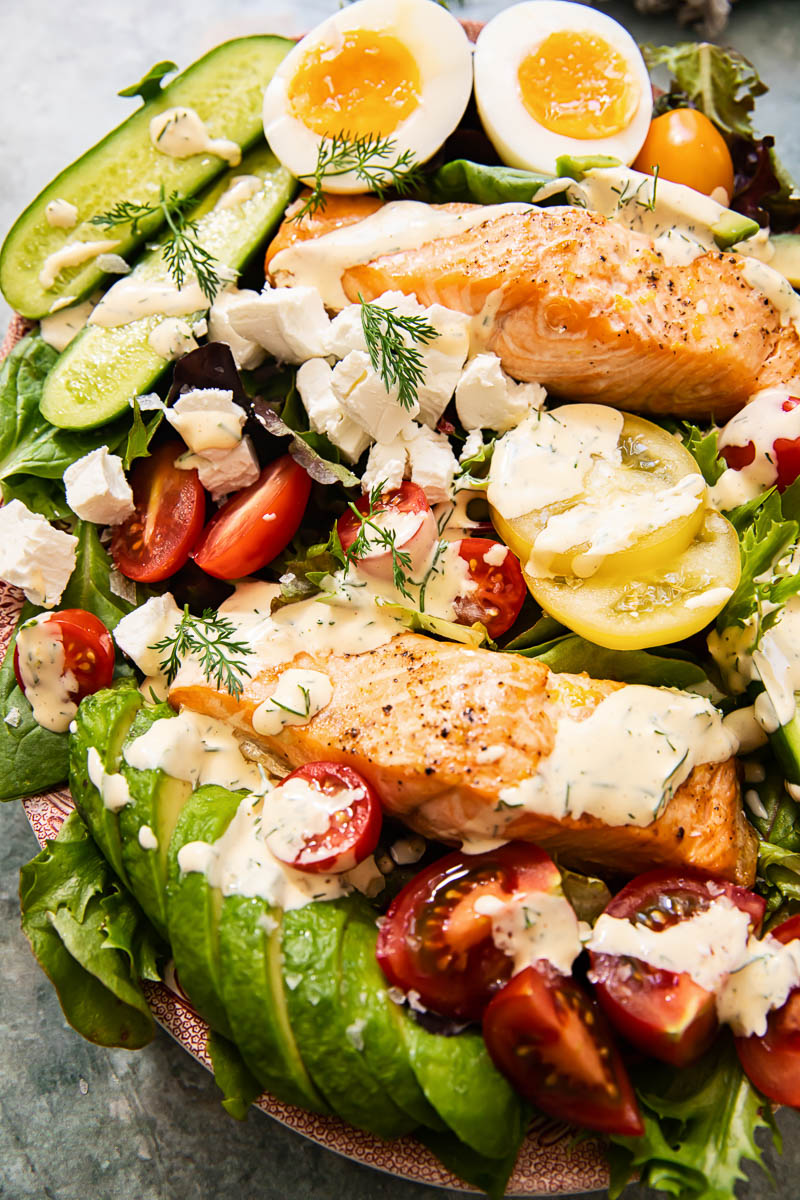 top down view of salad with salmon, avocado, eggs and creamy dressing