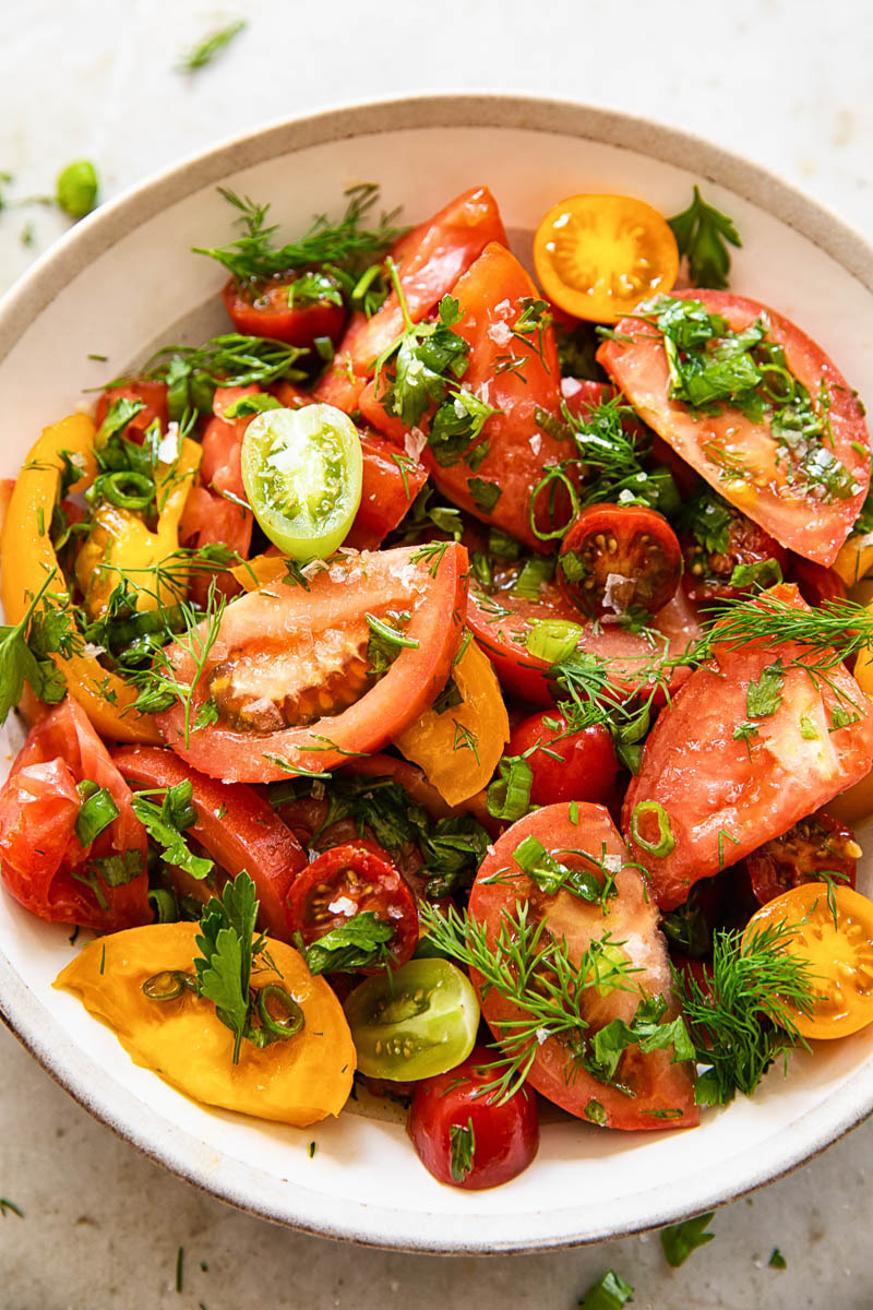 top down view of tomato and herb salad in a bowl