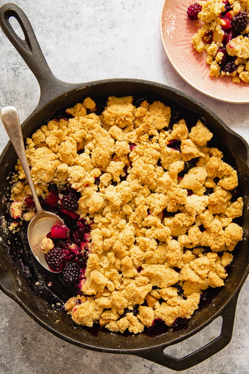 top down view of berry crumble in a cast iron pan