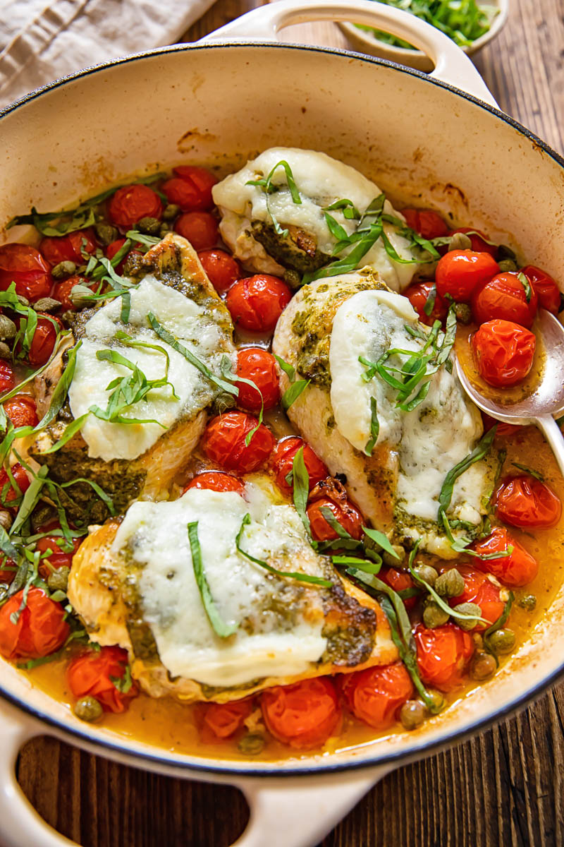 chicken caprese in a pan with cherry tomatoes