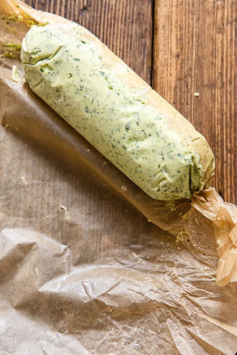 herb butter log being wrapped in parchment paper