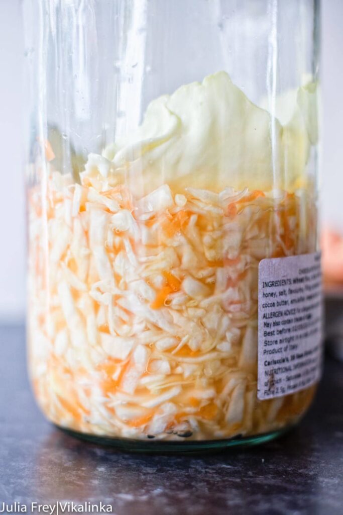 fermented cabbage and carrots in a large glass jar