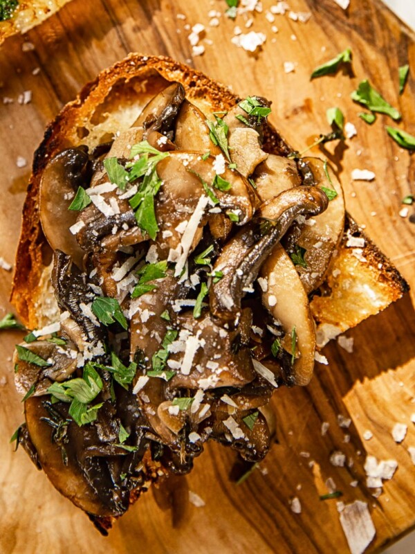 top down view of crostini topped with mushrooms, parsley and Pecorino Romano