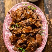 top down view of lamb in red wine sauce on a platter
