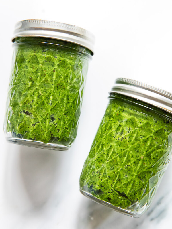 two mason jars filled with green pesto