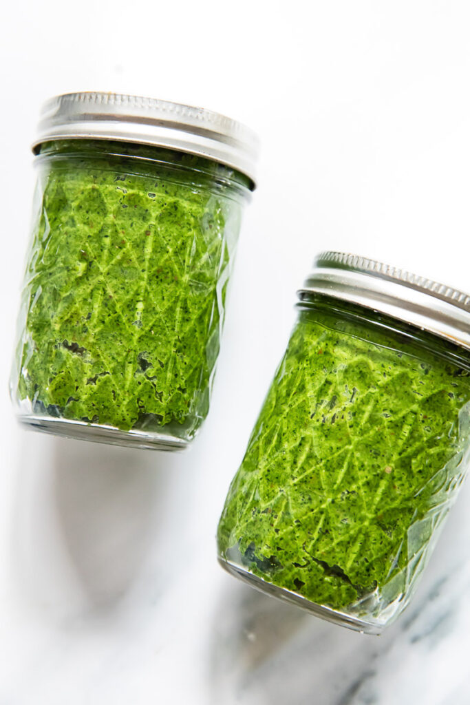 two mason jars filled with green pesto