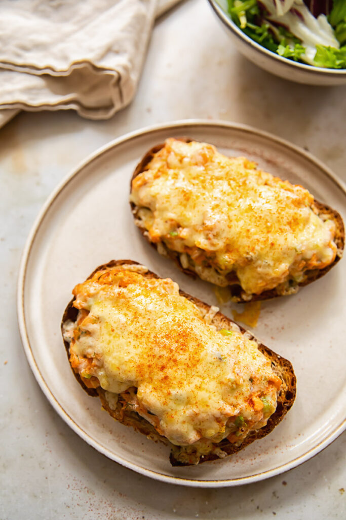 Hot cheesy salmon sandwiches on a plate