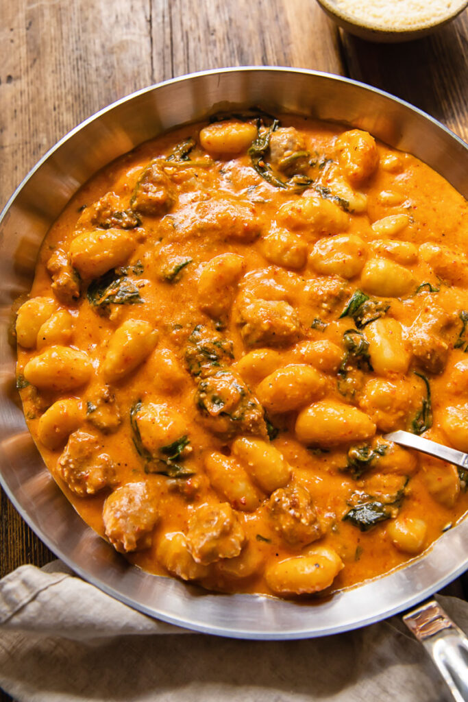 top down view of gnocchi with romesco sauce in a pan