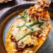 top down view of squash half stuffed with bolognese and topped with cheese