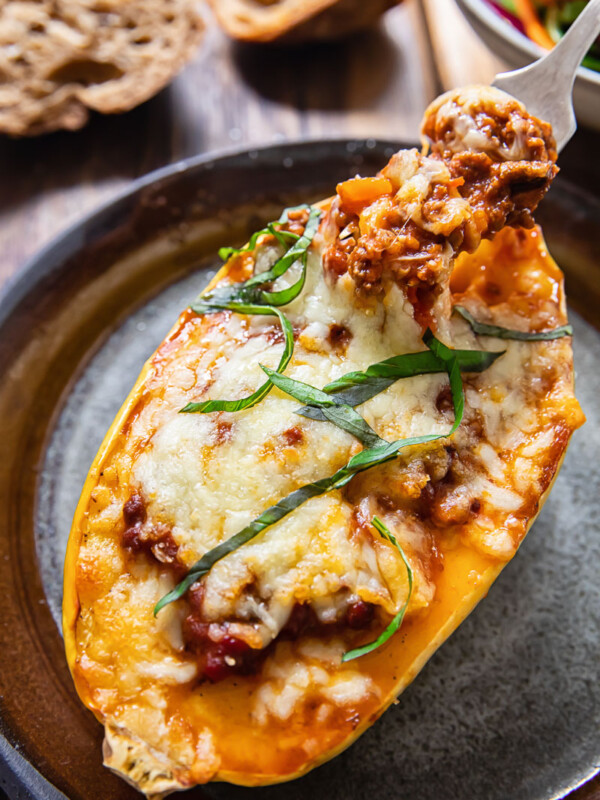 top down view of squash half stuffed with bolognese and topped with cheese