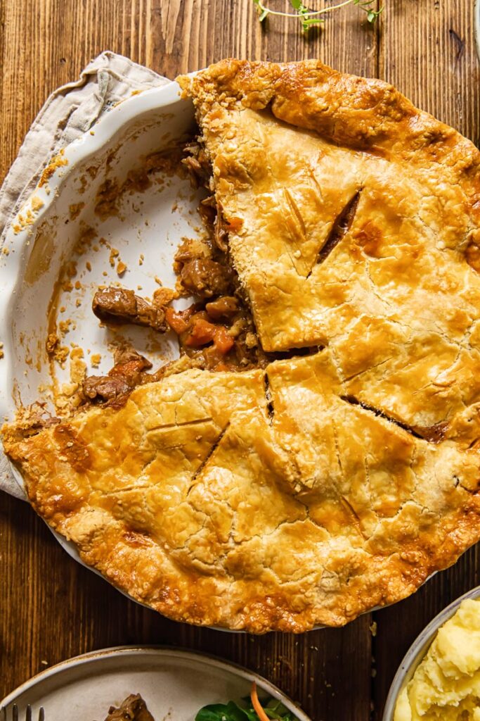 Top down of steak and ale pie with a piece removed