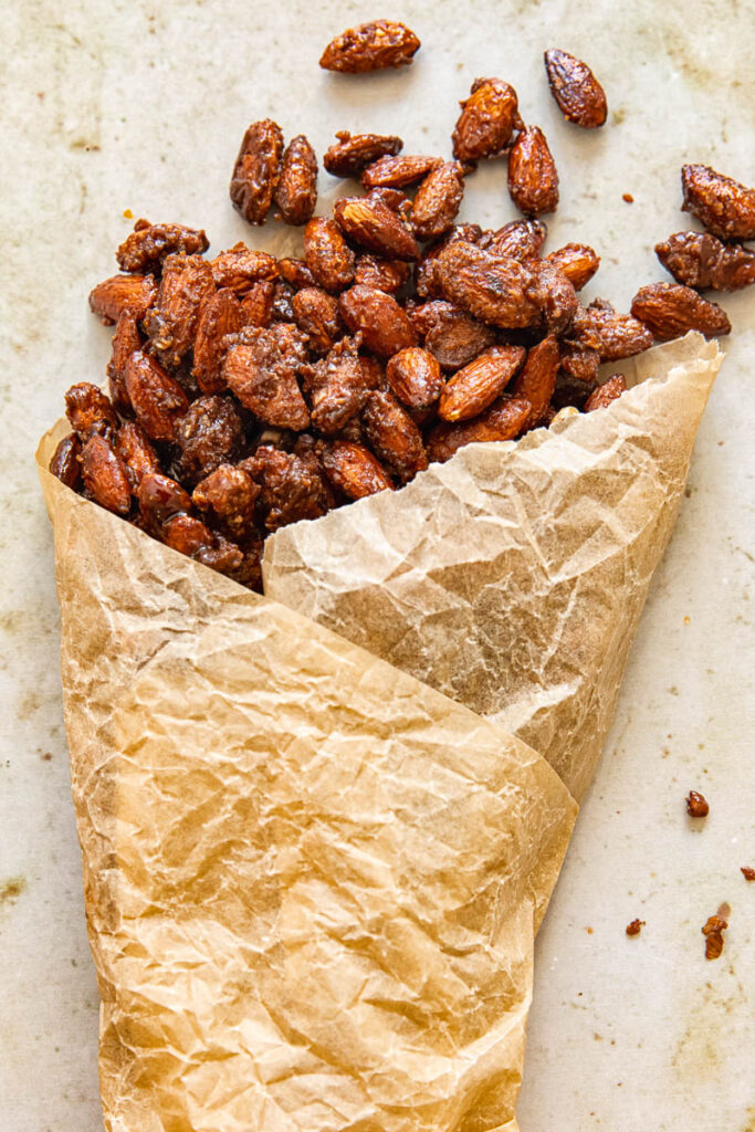 candied almonds spilling from parchment paper cone