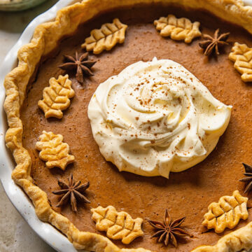 top down view of pumpkin pie topped with whipped cream in the middle