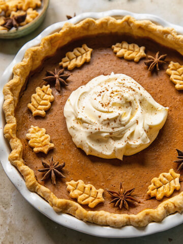 top down view of pumpkin pie topped with whipped cream in the middle