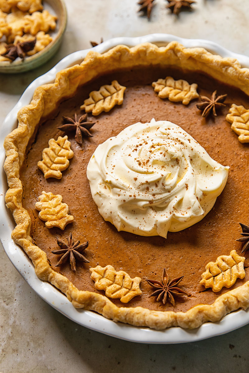 top down view of pumpkin pie topped with whipped cream in the middle