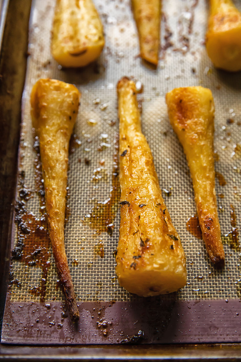close up of roasted parsnip on a roasting tray
