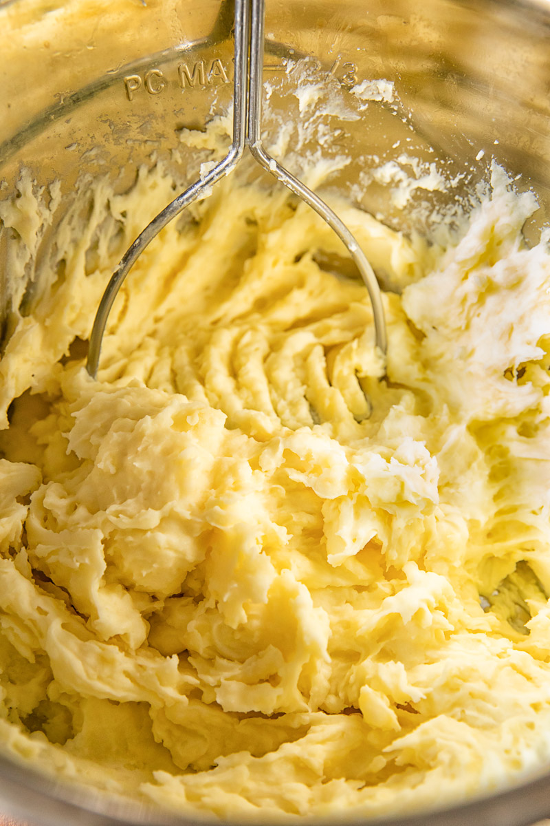 potatoes being mashed in a pot