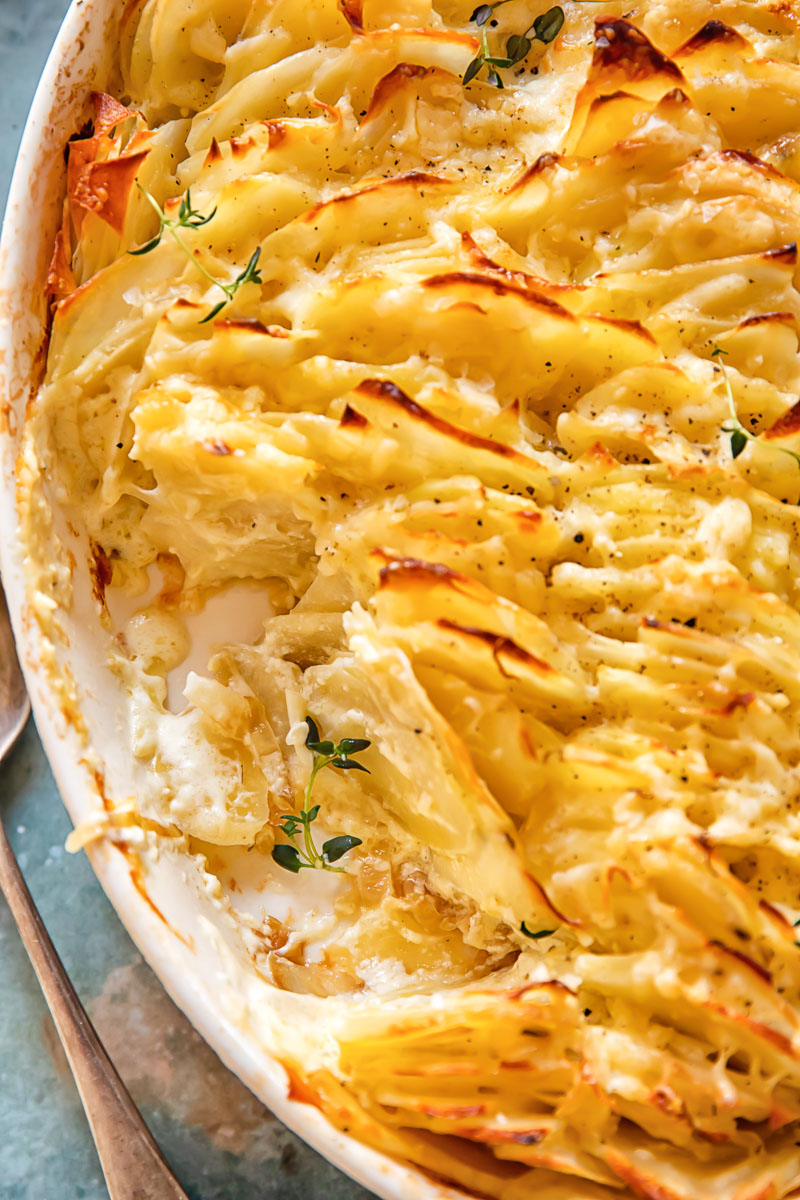 scalloped potatoes in a pan with a portion scooped out