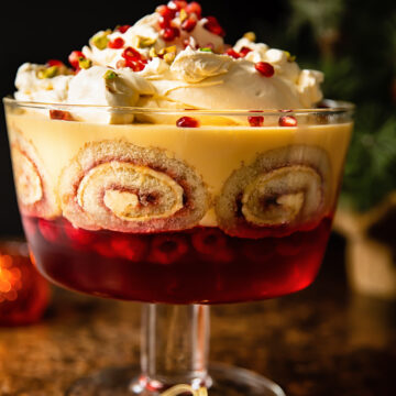 view of traditional trifle in a trifle bowl with Christmas tree in background