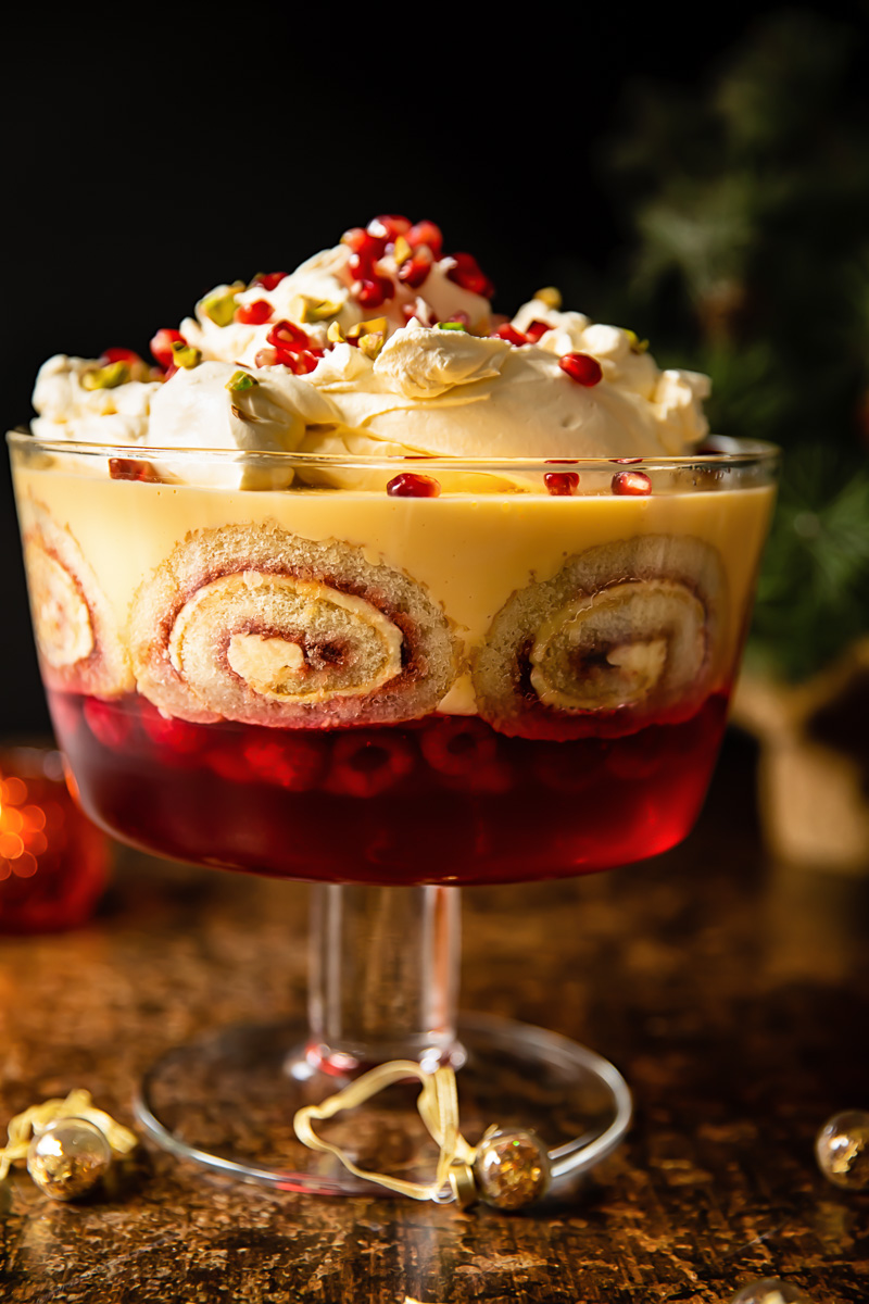 view of traditional trifle in a trifle bowl with Christmas tree in background