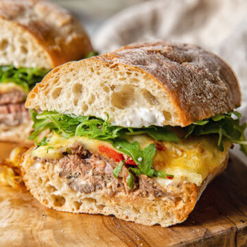 Hot roast beef sandwich on a wooden cutting board