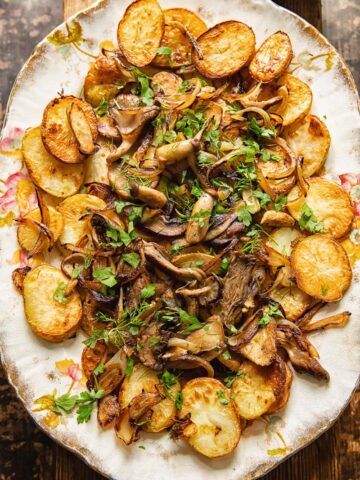 top down view of fried potatoes and mushrooms topped with herbs