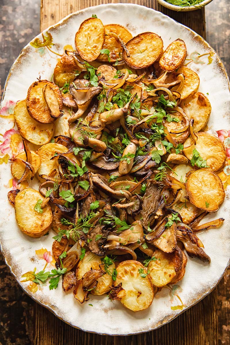 top down view of fried potatoes and mushrooms topped with herbs