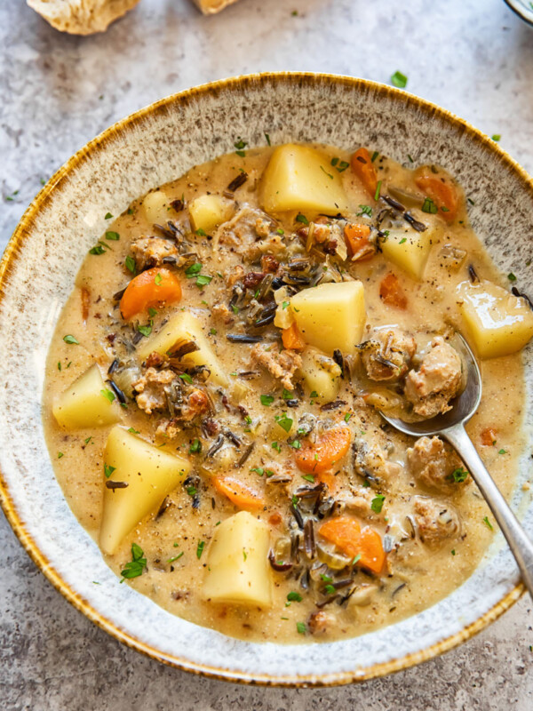 potato and sausage chowder in a soup bow with a spoon in it
