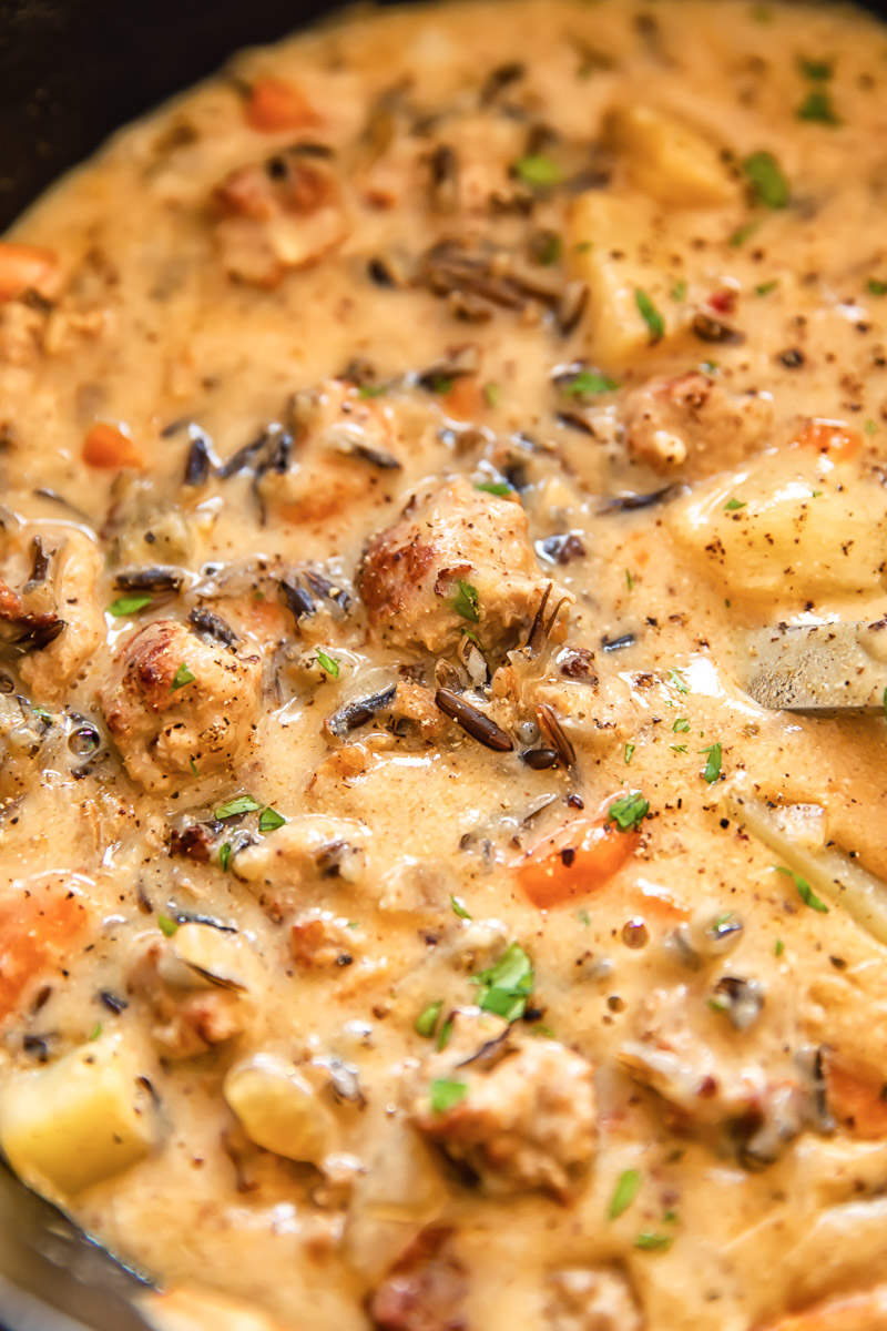 close up image of creamy soup with sausage chunks