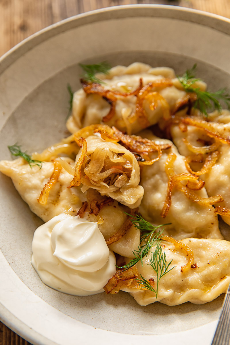 dumplings in a bowl, one of them showing the filling inside