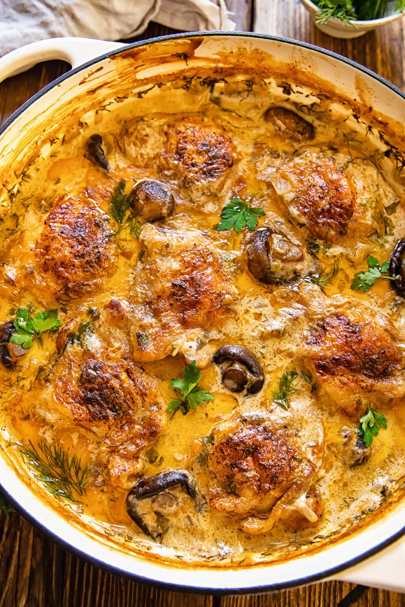 top down view of chicken and mushrooms in a creamy sauce in a round pan