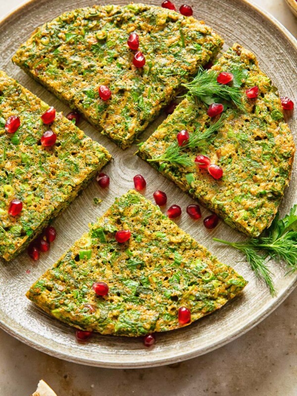 top down view of herby frittata cut into 4 wedges and topped with pomegranate seeds
