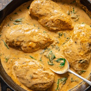 chicken breasts in a creamy sauce in a cast iron pan
