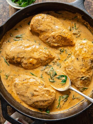 chicken breasts in a creamy sauce in a cast iron pan