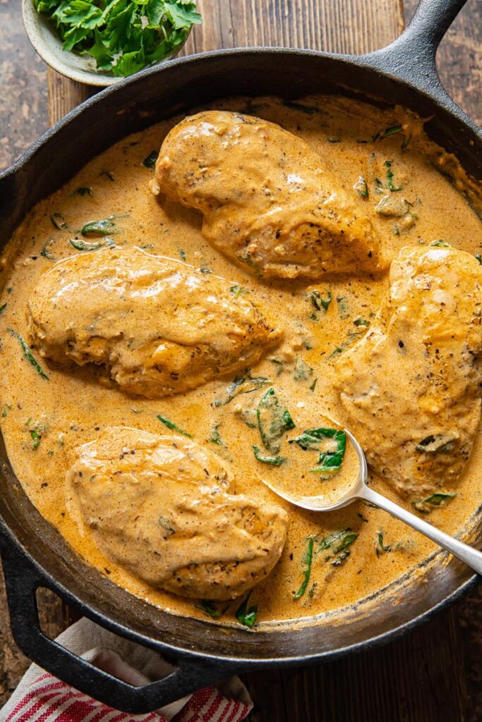 chicken breasts in a creamy sauce in a cast iron pan