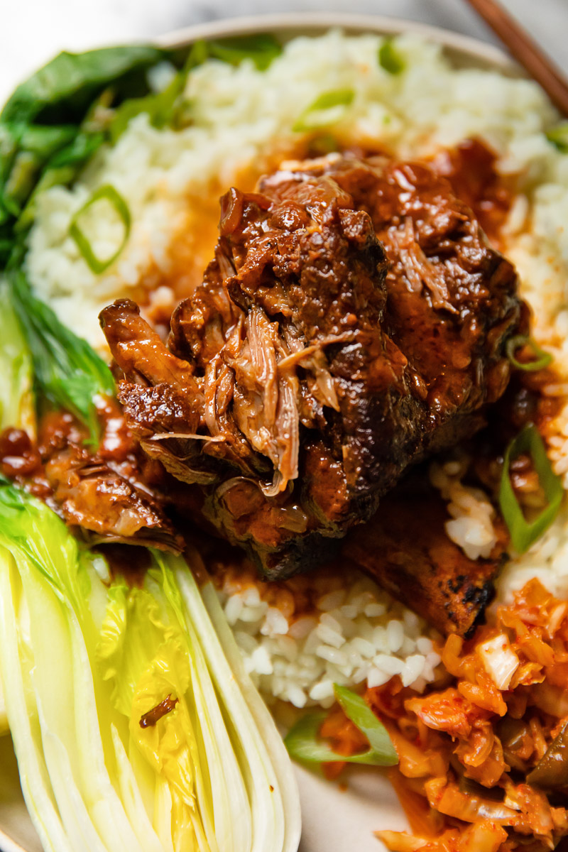 close up of short ribs on a bed of rice, bok choy