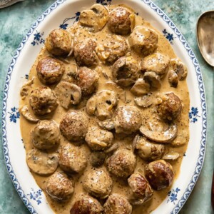 top down view of meatballs in a creamy sauce on a white and blue platter