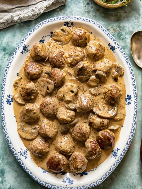 top down view of meatballs in a creamy sauce on a white and blue platter