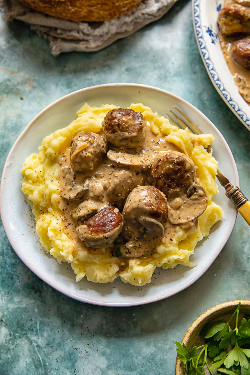 meatballs and sliced mushrooms in creamy sauce over mashed potatoes
