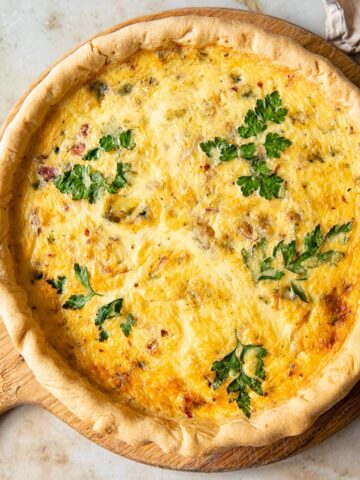 top down view of quiche on a round cutting board