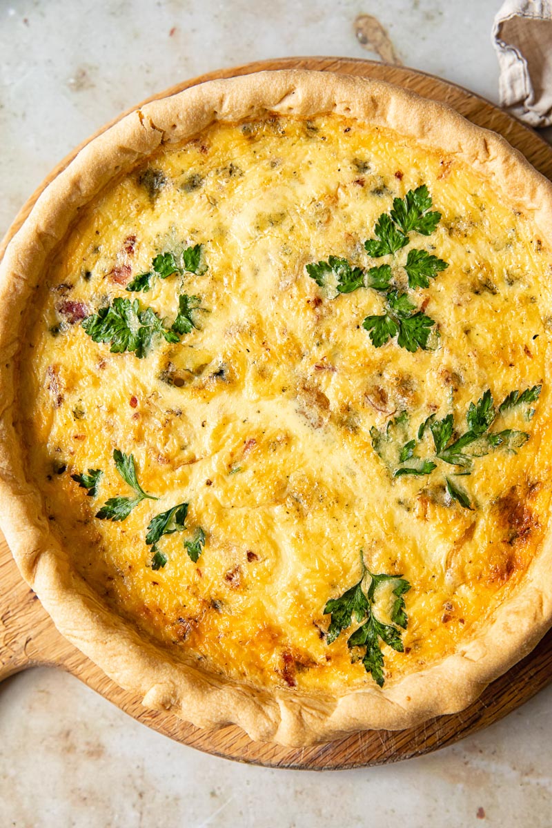 top down view of quiche on a round cutting board